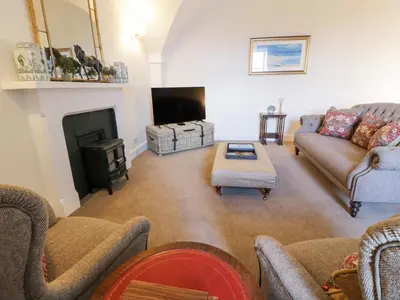 a living room with a couch and a fireplace at Brewhouse Flat - Culzean Castle in Maybole