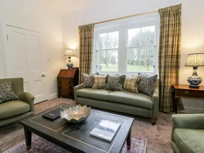 a living room with two couches and a table at Gate Lodge - Threave Estate in Castle Douglas