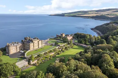 an aerial view of a castle on the shore of a lake at South Segganwell - Culzean Castle in Maybole