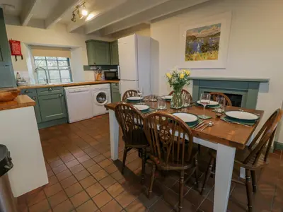 a kitchen with a table and chairs and a kitchen with green cabinets at Blue Door - Kirkcudbright in Kirkcudbright