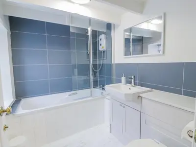 a bathroom with a tub and a sink and a shower at Blue Door - Kirkcudbright in Kirkcudbright