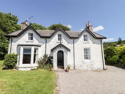 an old white house with a driveway in front of it at Port Donnel Cottage in Dalbeattie