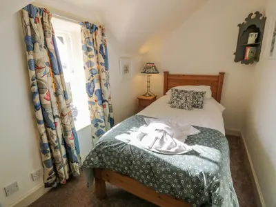 a bedroom with a bed and a window at Port Donnel Cottage in Dalbeattie