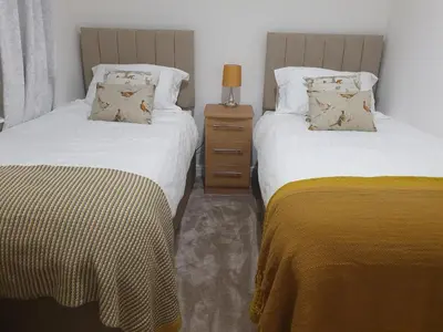 two beds sitting next to each other in a bedroom at 2-Bed Barn Hot Tub & Pet Friendly near Muirkirk in Cumnock
