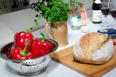 a bowl of peppers and a loaf of bread on a counter at The Stable At Oakbank in Elterwater