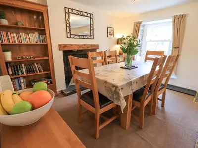 a dining room with a table and a bowl of fruit at Yew Tree Cottage Borrowdale in Rosthwaite