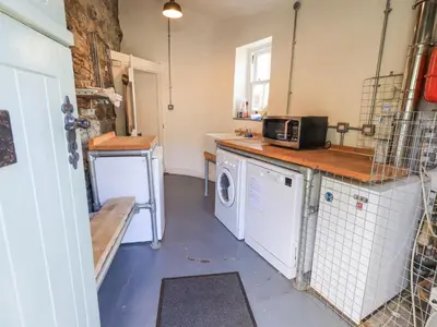 a kitchen with a washer and dryer in it at Yew Tree Cottage Borrowdale in Rosthwaite