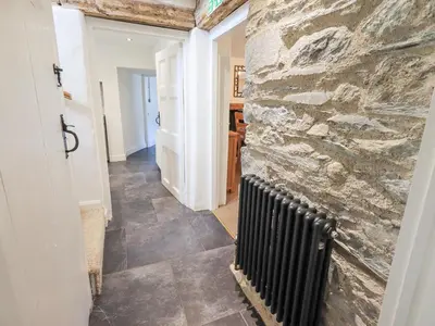 a hallway with a stone wall and a radiator at Yew Tree Cottage Borrowdale in Rosthwaite