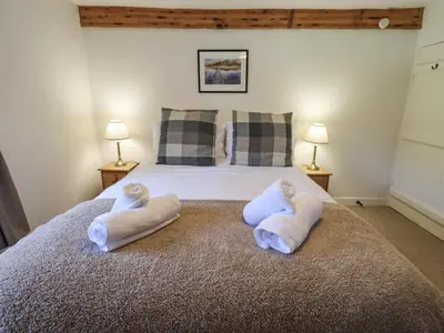 a bedroom with a bed with towels on it at Yew Tree Cottage Borrowdale in Rosthwaite