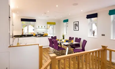 a kitchen and dining room with a table and purple chairs at Fell View in Keswick