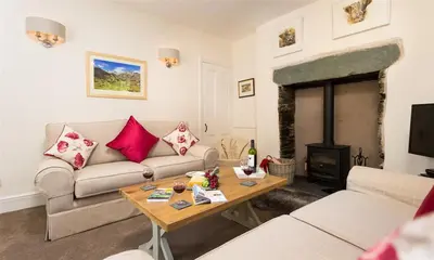 a living room with a couch and a table at Oxen Fell Cottage in Little Langdale