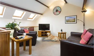 a living room with a dog sitting on the floor at Nest Barn in Keswick