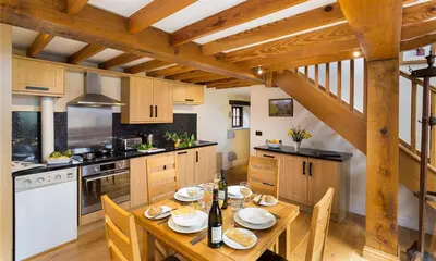 a kitchen with a wooden table with chairs and a tableablish at Nest Barn in Keswick