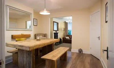 a kitchen with a wooden table and a mirror at Noble Cottage in Keswick