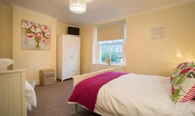 a bedroom with a bed and a window at Noble Cottage in Keswick