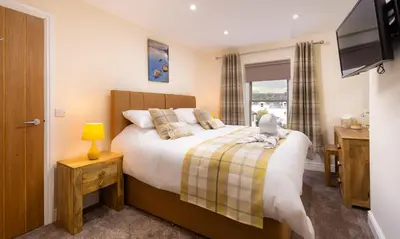 a bedroom with a bed with a teddy bear on it at Dovedale in Keswick