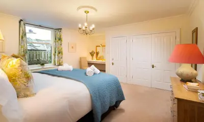 a bedroom with a large bed with a blue blanket at One The Howe in Portinscale