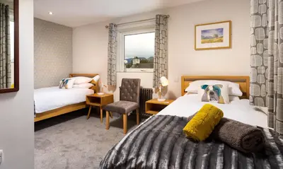 a hotel room with two beds and a window at Sunnybank Cottage in Keswick