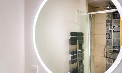 a bathroom with a mirror and a shower at Sunnybank Cottage in Keswick