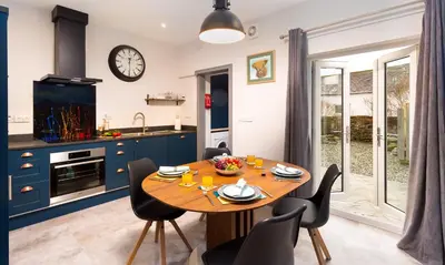 a kitchen and dining room with a wooden table and chairs at Sunnybank Cottage in Keswick