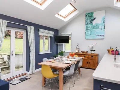 a kitchen and dining room with a wooden table and chairs at Merlestead in Applethwaite