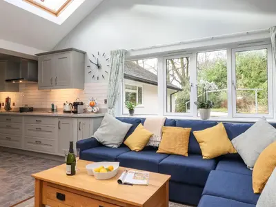 a living room with a blue couch with yellow pillows at Merlestead in Applethwaite