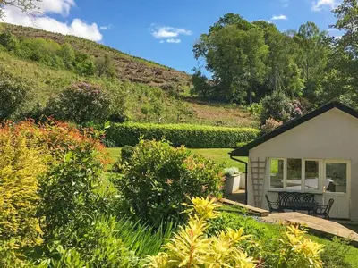 a house in a garden with a hill in the background at Merlestead in Applethwaite