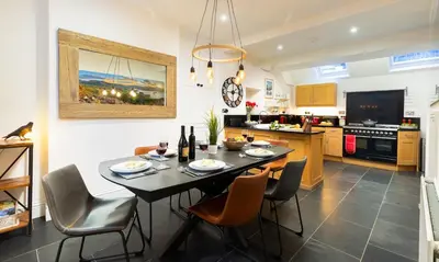 a kitchen and dining room with a table and chairs at Crow Cottage in Keswick