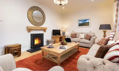 a living room with a couch and a fireplace at Crow Cottage in Keswick