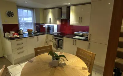a kitchen with a wooden table with a potted plant on it at Townfoot Cottage in Elterwater