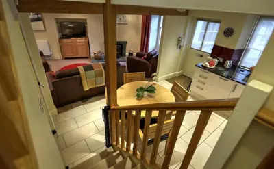 a kitchen and living room with a table in a room at Townfoot Cottage in Elterwater
