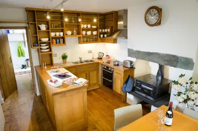 a kitchen with wooden cabinets and a counter top at Oakbank in Elterwater