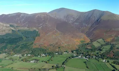 an aerial view of a mountain with a town in the foreground at Barn Cottage in Cockermouth