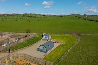 an aerial view of a barn in a field at The Stag Pod Farm Stay with Hot Tub Sleeps 2 in Galston