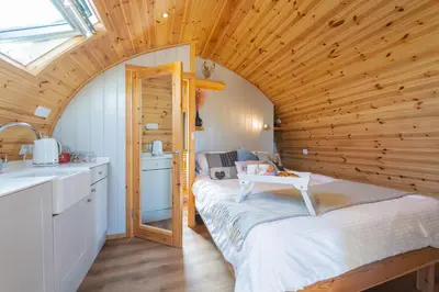 a small room with a bed in a wooden ceiling at The Stag Pod Farm Stay with Hot Tub Sleeps 2 in Galston