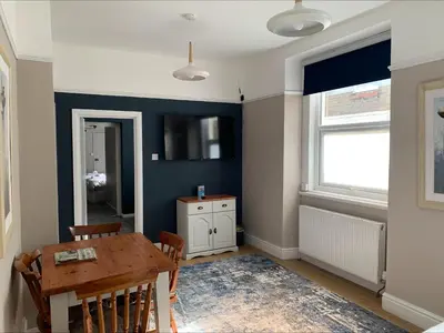 a dining room with a table and a blue wall at Arrandale Apartments in Douglas