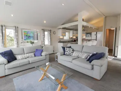 a living room with two couches and a table at Oyster Bay Lodge in Dalbeattie