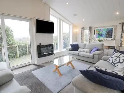 a living room with two couches and a tv at Oyster Bay Lodge in Dalbeattie