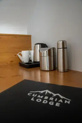 a table with two coffee cups and a mat on it at Cumbrian Lodge in Seascale