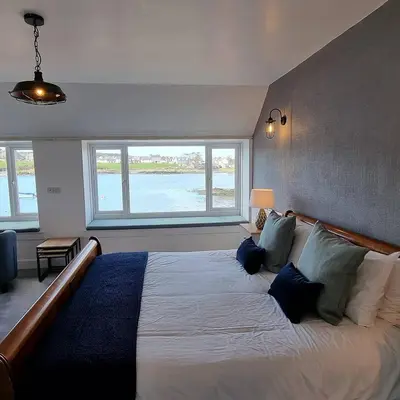 a bedroom with a large bed with a large window at The Steam Packet Inn in Isle of Whithorn
