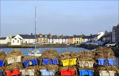 a bunch of boats are docked in the water at The Steam Packet Inn in Isle of Whithorn