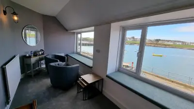a room with two windows with a view of the water at The Steam Packet Inn in Isle of Whithorn