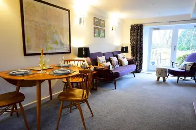 a living room with a table and a couch at Bottom Shop, Elterwater in Chapel Stile