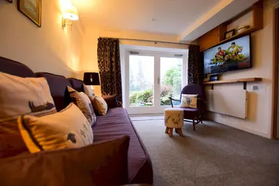 a living room with a couch and a large window at Bottom Shop, Elterwater in Chapel Stile