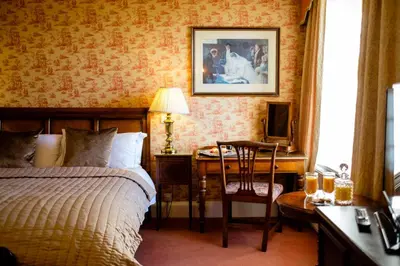 a bedroom with a bed and a desk with a chair at The Gretna Chase Hotel in Gretna