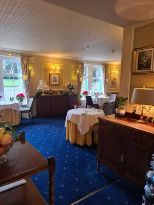a dining room with two tables and a room with tablesktop at Balcary Bay Country House Hotel in Auchencairn