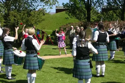 a group of girls in tartan kilts playing drums at Heron Lodge, edge of Mabie Forest Dumfries in Dumfries