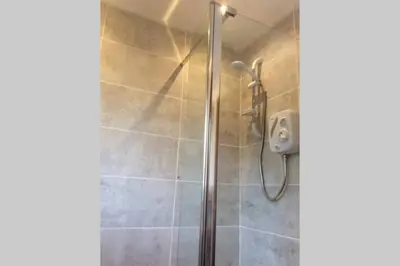 a shower with a glass door in a bathroom at Heron Lodge, edge of Mabie Forest Dumfries in Dumfries
