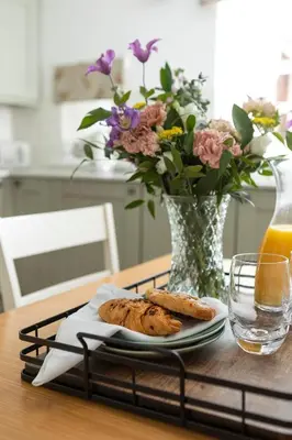 a table with a plate of bread and a vase with flowers at Stableyard Studio: Drumlanrig Castle in Thornhill