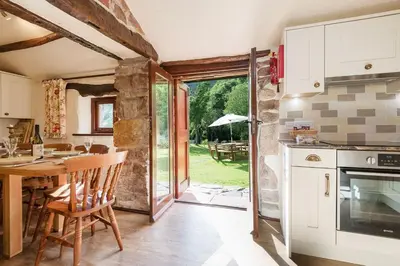 a kitchen with a table and a dining room at Bridge End Farm Cottages in Boot